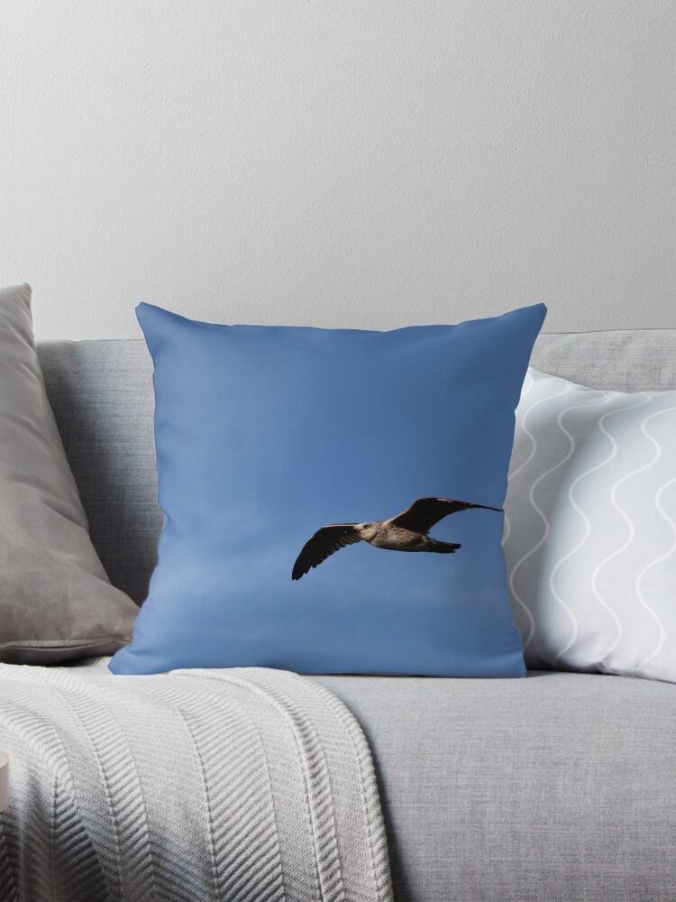 Juvenile seagull in flight blue sky coastal throw pillow