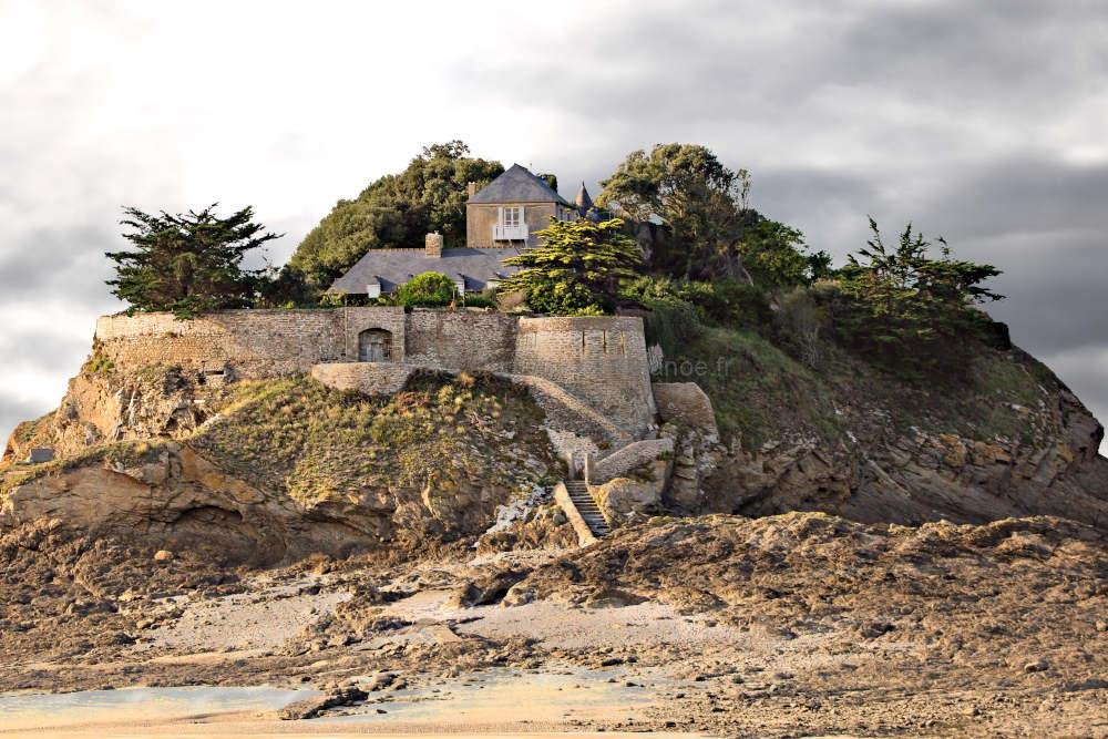 Fort du Guesclin tidal island under a soft overcast sky. Authentic view of the historic French fort in Saint-Coulomb near Saint-Malo. Realistic coastal landscape at low tide.