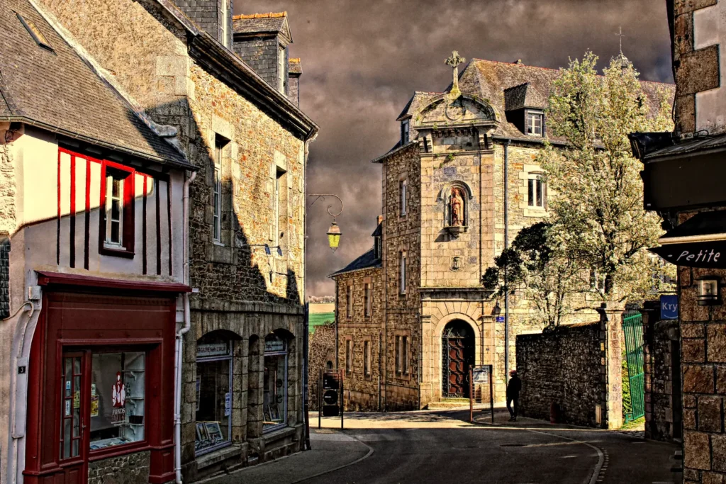 Charming historic street in Tréguier with stone houses under dramatic sky, Brittany